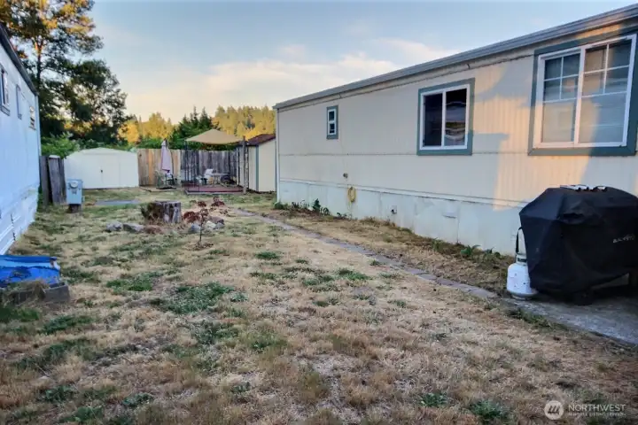 Side yard with outdoor space and additional storage structures. Side yard with outdoor space and additional storage structures.