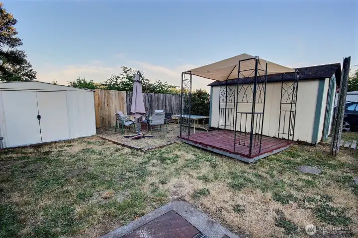 Backyard area with gazebo, deck space, shed, and firepit area. Backyard area with gazebo, deck space, shed, and firepit area.