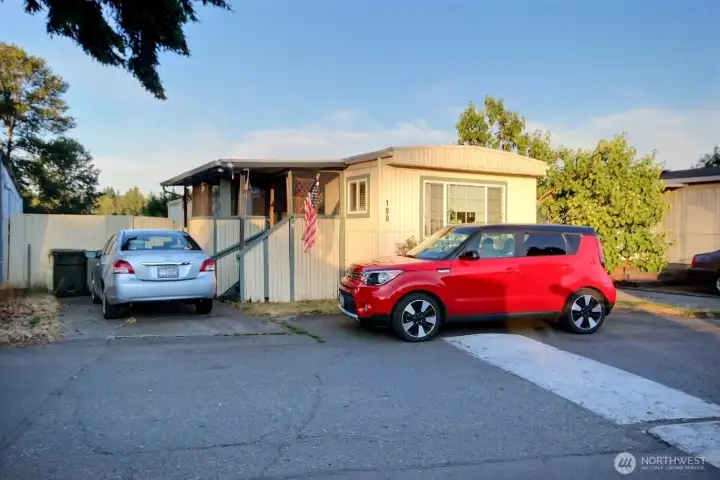 Exterior front view showing manufactured home entry, covered porch, and two assigned parking spaces. Exterior front view showing manufactured home entry, covered porch, and two assigned parking spaces.