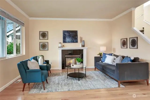 The living room features a gigantic window overlooking the front yard and a cozy gas fireplace adds ambiance and warmth.
