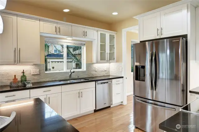 Brand new stainless steel appliances were added in 2023.  Beautiful white shaker cabinetry wraps around the kitchen and is accented by black granite countertops with gleaming glass backsplash.
