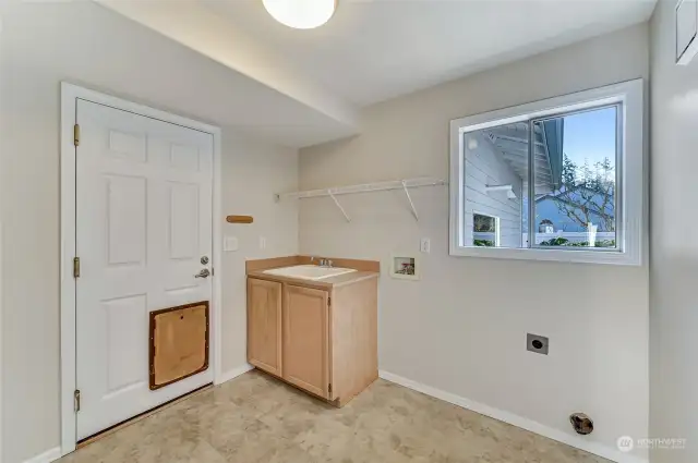 Main floor laundry room with a utility sink.