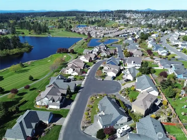 Gated community with cul-de-sacs on either side and pond with a walking trail.