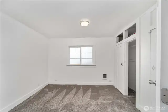 This light and bright bedroom offers fresh carpet, a large window for natural light, and charming built-in closets with overhead cubbies for extra storage. Whether you're furnishing your first home or creating a stylish rental, this room checks all the boxes for comfort and functionality.