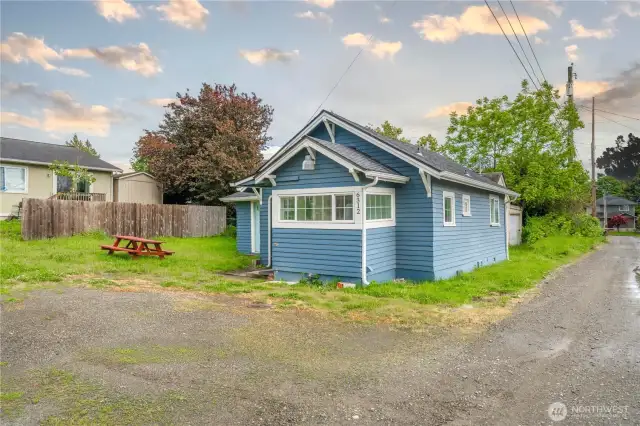 Fresh exterior paint gives this 1-bedroom home standout charm, complemented by a low-maintenance yard and gravel alley access. The picnic table and open lawn space add a touch of lifestyle potential—great for relaxing or casual outdoor dining.