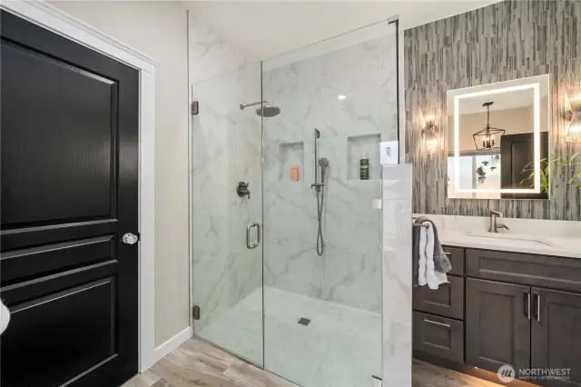 The spa-inspired en-suite bath envelops you in a marble tile shower.