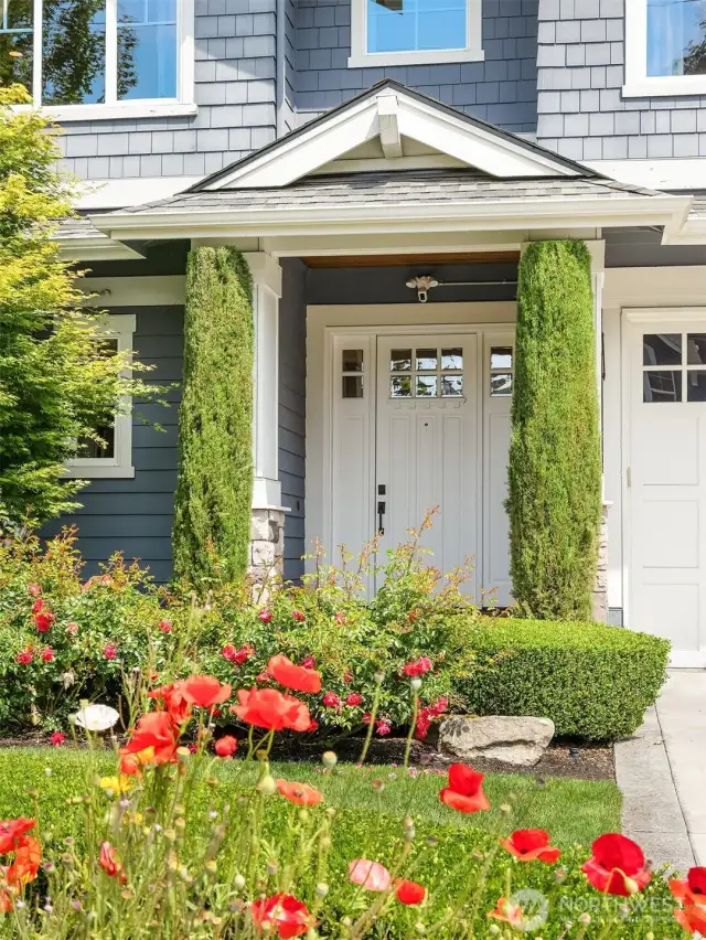 A cheerful welcome to this Enatai gem—vibrant blooms, manicured hedges, and a classic covered entry set the tone for timeless elegance.
