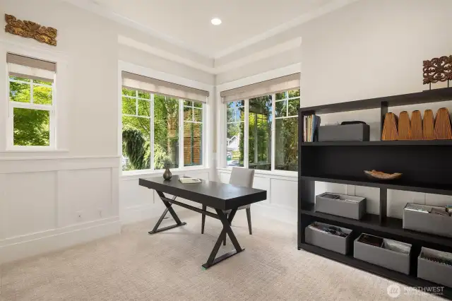 Flexible main floor space with corner windows and elegant millwork—ideal as a sunlit home office or easily converted into a main-level bedroom to suit your needs.
