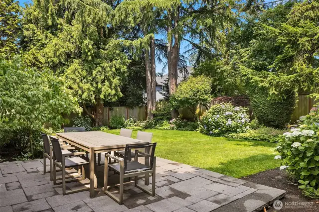 Lush, level, and beautifully private—this backyard is a true retreat. Host summer dinners on the paver patio surrounded by hydrangeas, mature evergreens, and vibrant landscaping that feels like your own secret garden.