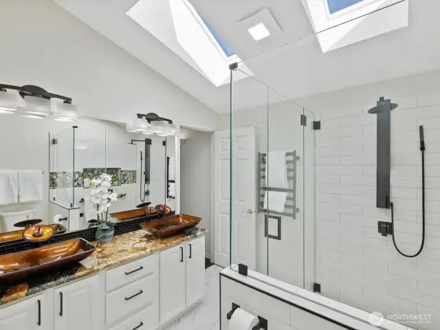Primary bathroom aslo has vaulted ceilings with sky-lights