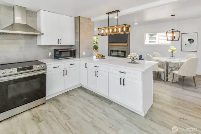 Virtually staged. View of kitchen and dining room with a peak of the fireplace.
