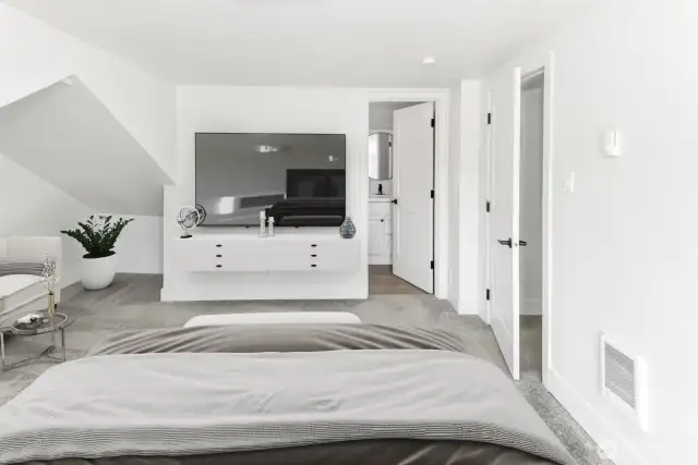 Virtually staged. Primary bedroom with peak into en-suite bathroom and closet.