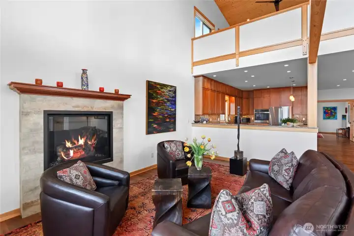 This sitting area by the fireplacet is located next to the open kitchen. One of two primary suites is just above. The pony wall provides privacy for one of the primarys.