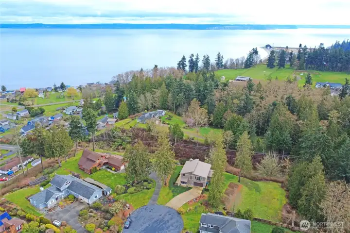 Drone shot of the area with subject in lower center and Hansville Lighthouse in the top right.