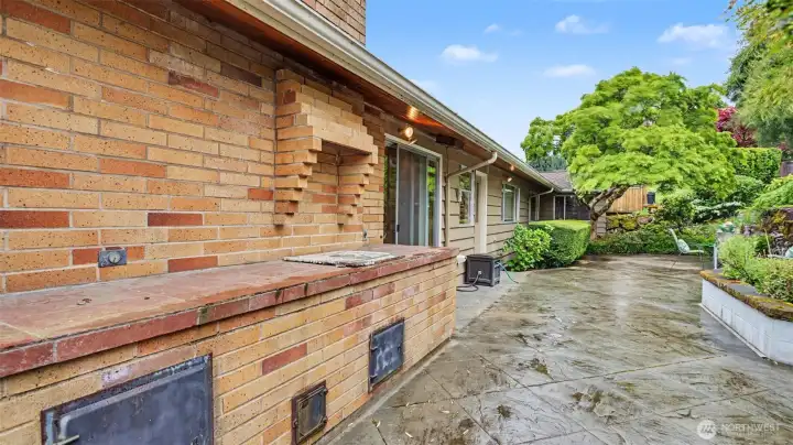Large concrete patio with built in brick BBQ.
