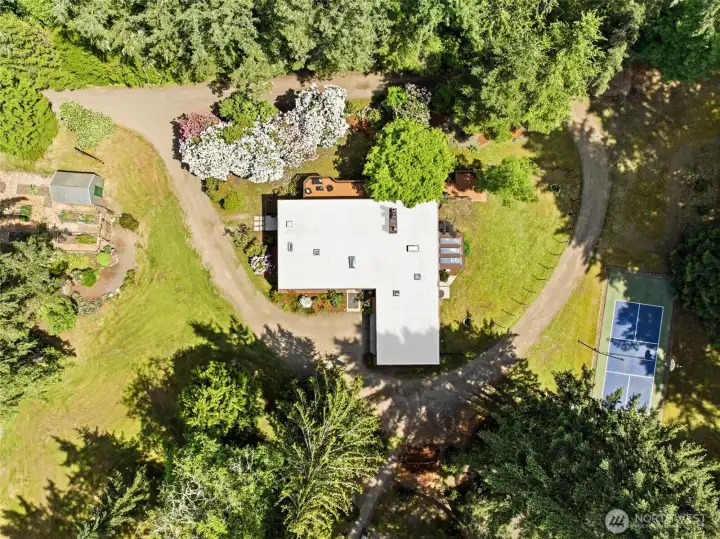 Over 3800 SF home on 4.62 acres with a sports court, garden & firepit areas, trails etc.