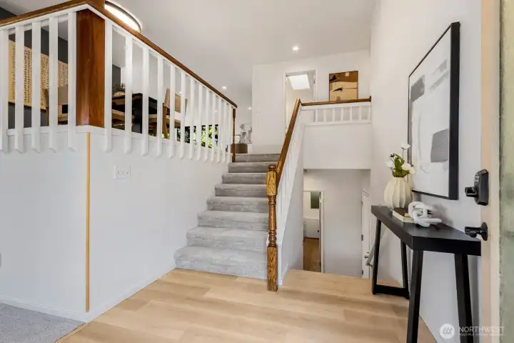 3 choices when you walk in the home.  To the left: formal living room with soaring, natural plank ceiling, fireplace and floor to ceiling windows.  Downstairs, extra large bonus room, utility room and upstairs is the main floor of the home.