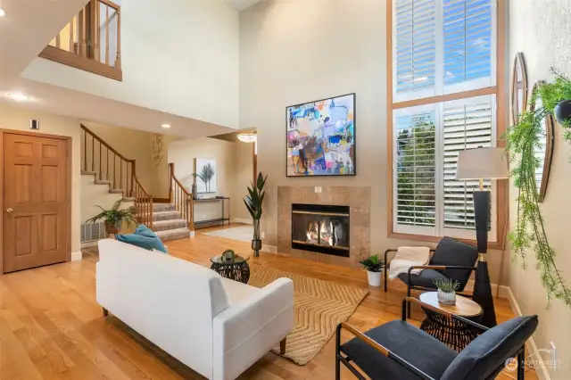 The two story window with custom shutters makes this living area delightfully bright even on a cloudy day.
