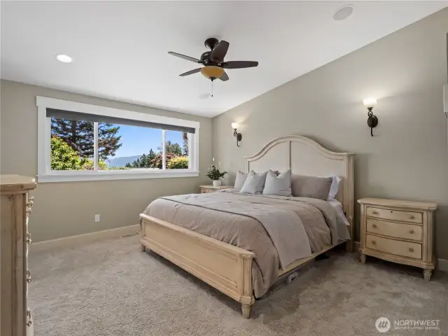 Bathed in natural light, the room boasts a generous window offering scenic outdoor views, perfectly enhancing the calm, neutral tones of the walls and carpeting