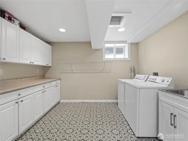 A well-appointed laundry room and craft area, boasting modern white cabinetry that provides extensive storage.