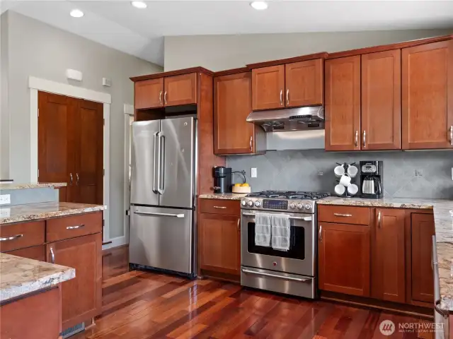 Boasting beautiful wood cabinets and durable hardwood flooring, the space combines timeless elegance with everyday practicality.