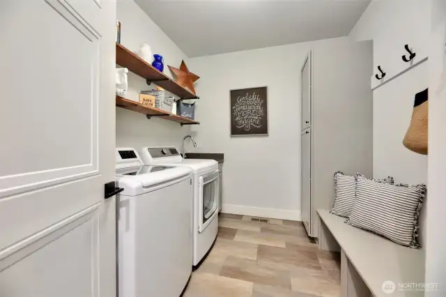 Spacious laundry room with storage and bench