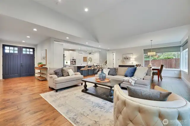 The Main Living Area... view of the entry, office and primary suite to the left, kitchen in the distance, then the hallway to the garage, main-level powder room, and staircase to the second story