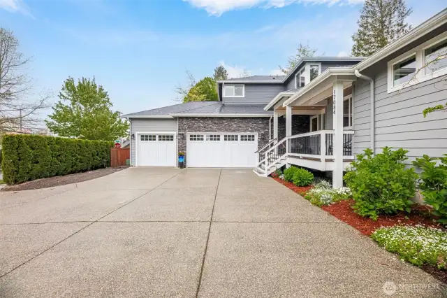 A spacious 3+ car garage with 12-foot ceilings for RV parking or a car lift, 26-foot depth, finished walls, built-in storage, and extra LED lighting. Includes a large storage room with shelving and hot/cold water spigots for added convenience.