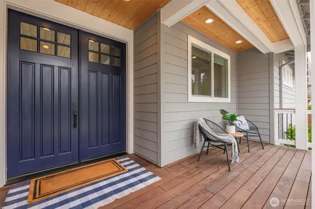 A spacious covered front porch with a tongue-and-groove ceiling and French door entry, offering an inviting and elegant welcome with ample room to relax.