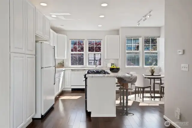 Open concept kitchen layout with granite counters, gas range in center island, breakfast bar & eating space. Virtually staged to show potential.
