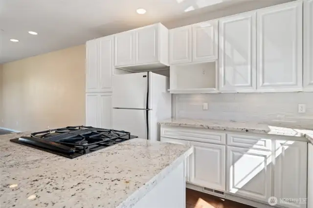 Bright kitchen with tall windows, ceiling spots and more.