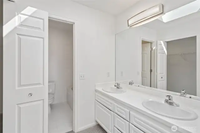 Primary bathroom with 2 sinks, new lighting, large walk in closet, fresh paint and new carpets!