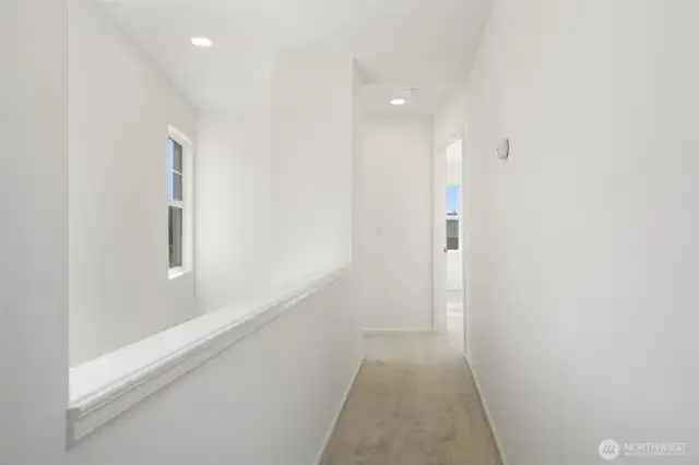 Upper level hallway between primary and additional bedroom and full bathroom. All fresh paint and carpets - attic fan too!