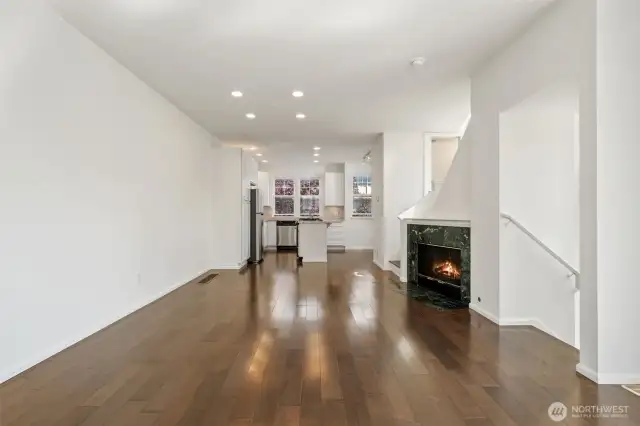 Expansive main area with canned lights, wood floors, fresh paint, gas fireplace - plus kitchen and laundry all accessible for easy living.