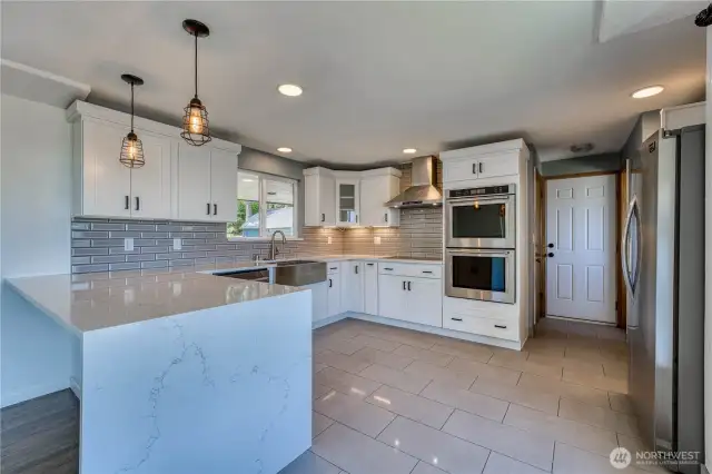 Here is an angle view of the beautiful, updated kitchen, lots of counter space and lots of cabinetry, stainless appliances, make this kitchen a dream.  Nice pendant lights above the breakfast bar/counter space and the recessed lighting make for a light and bright space