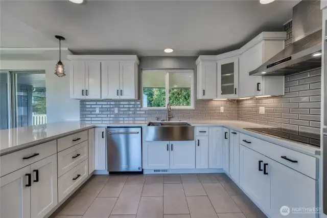 Gorgeous tiled floor and backsplash, farmhouse sink in the updated, modern kitchen with lots of beautiful cabinetry and stunning marble counter tops along with stainless appliances.  Nothing to do here but start cooking.