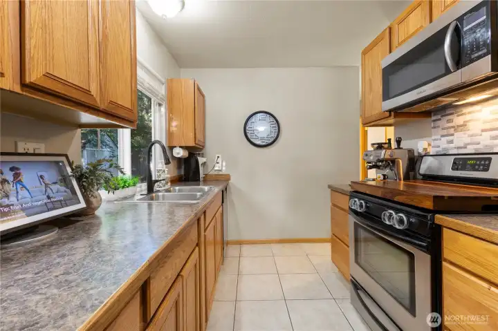 Large Walk-through kitchen that looks to backyard of home, with SS Appliances that will stay.  The Fridge was just recently replaced in 2024