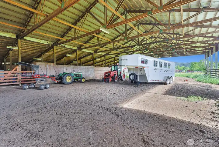 Indoor arena with tons of storage and attached stalls.