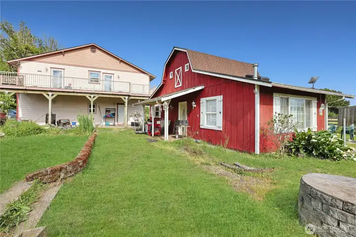 Back of home with massive deck overlooking your garden and greenhosue. Red structure is a flex space which is heated and has 2 bathrooms. A great place to hang out and get away.