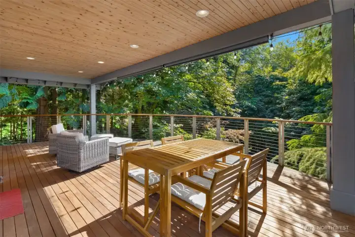 The covered back deck offers tons of space for multiple sets of outdoor furniture, plus a calming view of the surrounding trees.