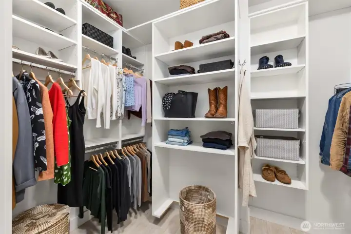 This spacious walk-in closet is thoughtfully outfitted with built-in shelving and ample storage solutions.