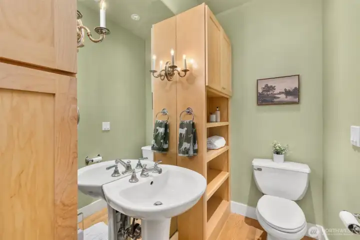 Main level powder room with plenty of storage and quaint pedestal sink.