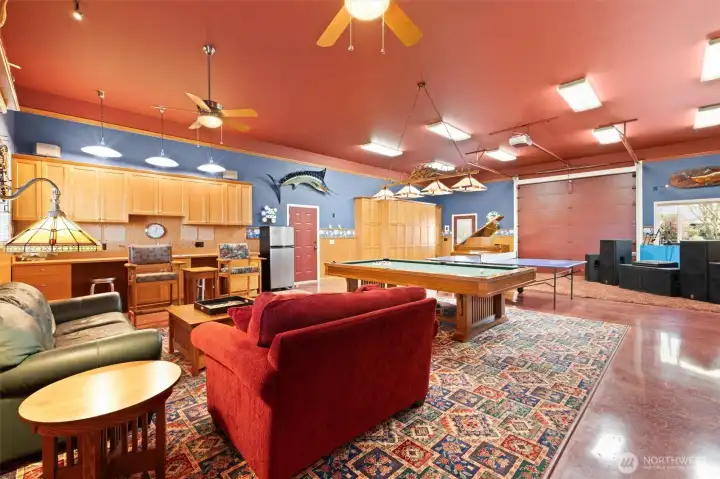 GAME ROOM! The garage door makes it easy to absorb lots of guests during warm season parties. Notice the strategic painting which makes the garage door and its hardware blend into the ceiling. Kitchen sink and abundant cabinet storage. The red door at the center leads to the ADU garage.