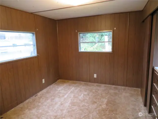 The other corner of the larger bedroom.  Total of three windows.  To the left is southern view and overlooks the carport and little shed behind.