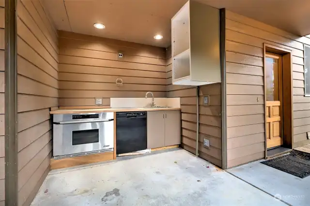 Outdoor kitchen with a dishwasher, sink and another oven!