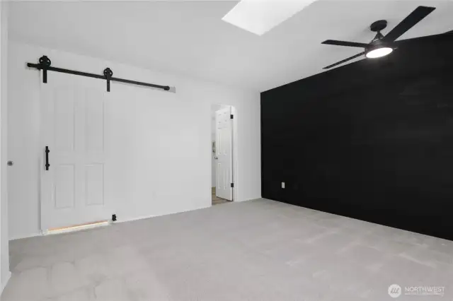 Primary bedroom showing barn style door to bathroom and walk-in closet to the right.