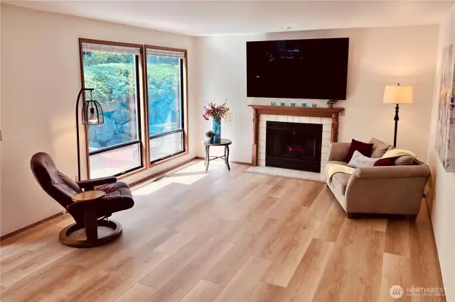 Family room looking west into backyard with large windows. New wood flooring with open living space into kitchen