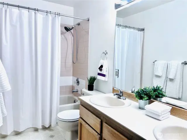 Full bathroom view from hallway entry with newer hardware.