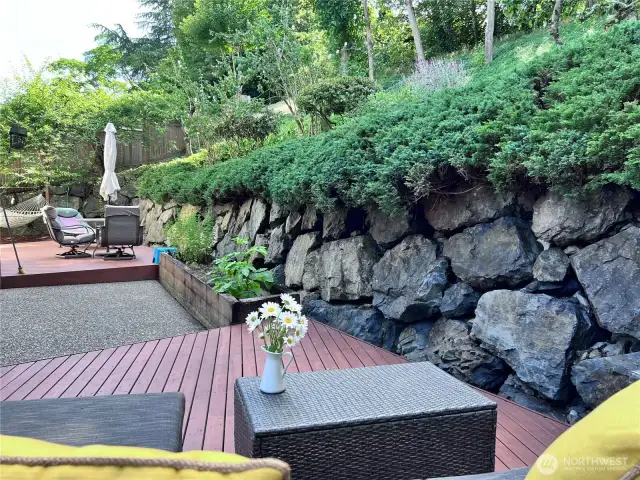 Two built patio decks on ground level. Full retaining wall all around the back of the property. Slops to large hill with built in steps and path access to your private trail.