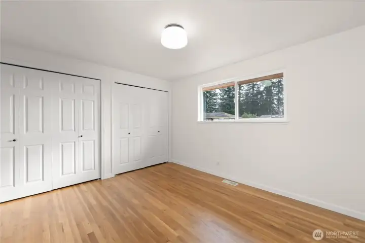 Spacious primary bedroom featuring dual closets, abundant natural light, and an attached bathroom for added convenience and comfort